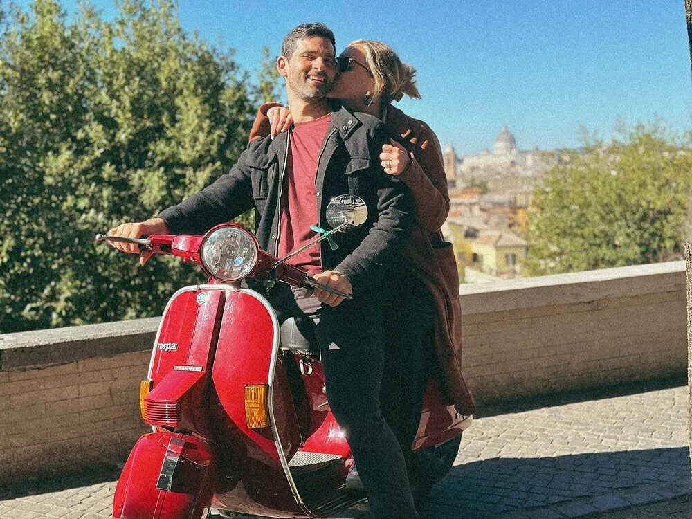 Coppia in abbraccio a bordo di una Vespa con vista panoramica su Roma