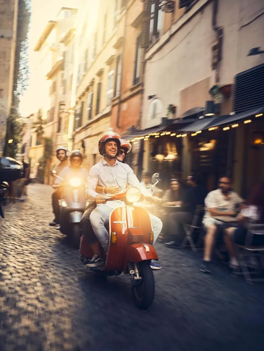 Gruppo in Vespa tra i vicoli del centro storico al tramonto