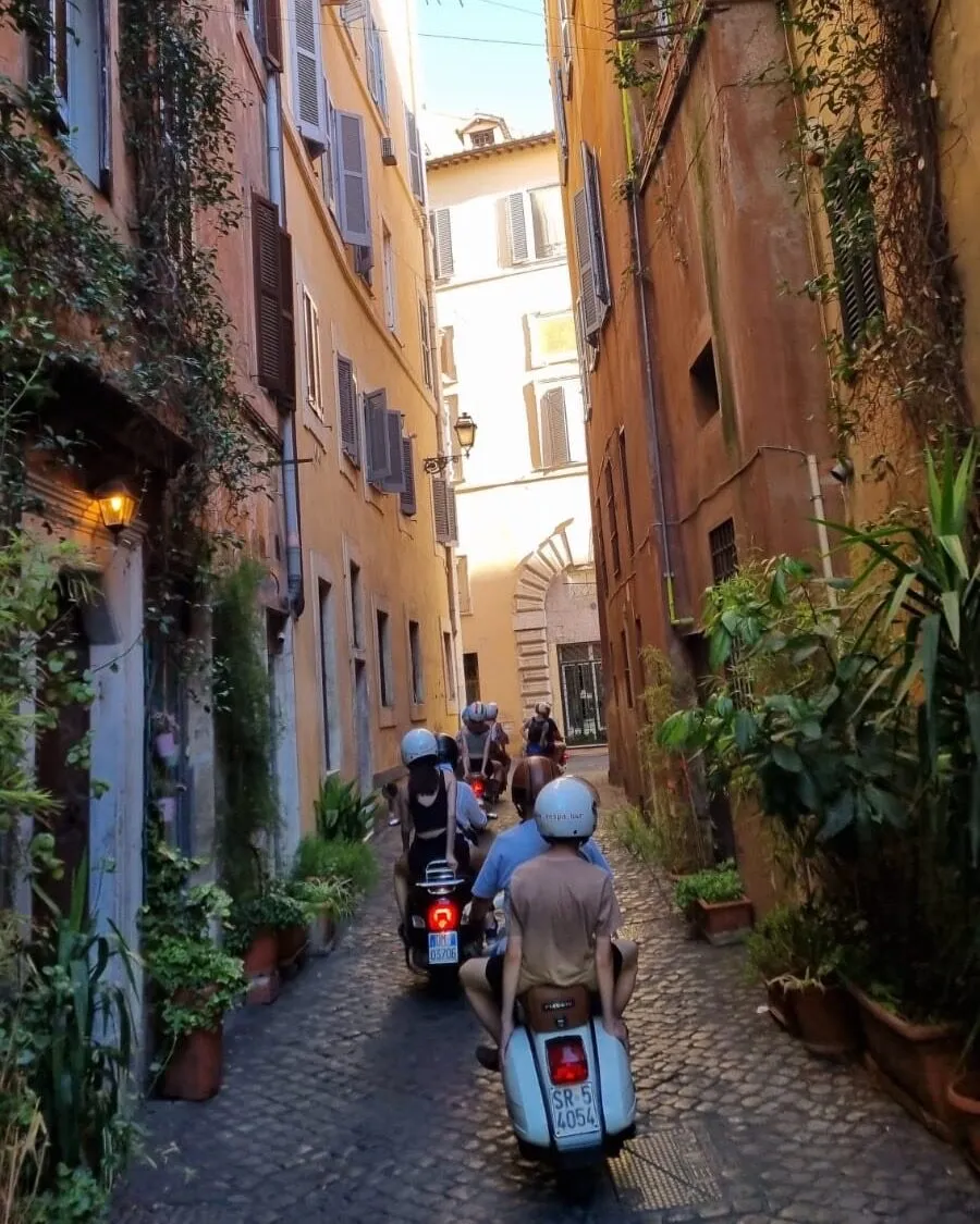 Vespa tra i vicoli di Trastevere ricoperti di edera