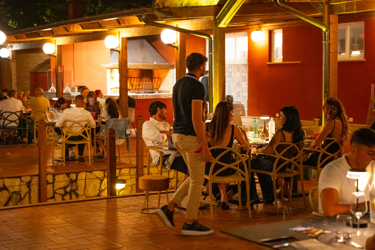 Ospiti a cena nel giardino illuminato del Tiber Village